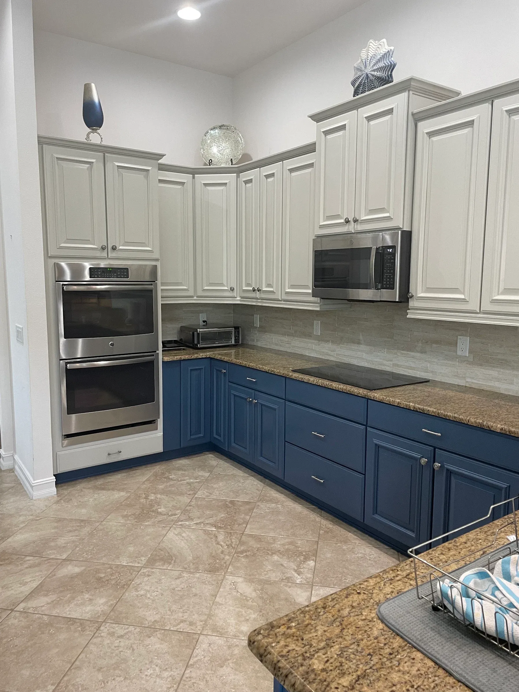 A kitchen Premier painted, with white upper cabinets over navy lowers